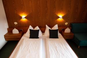 梅拉诺美泉宫酒店的一间卧室配有两张床和一张绿色椅子