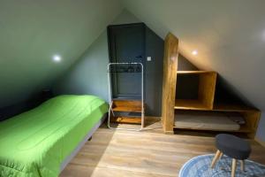 卡夫尔高原Agréable chalet Au milieu des sapins的阁楼上一间卧室配有绿色的床