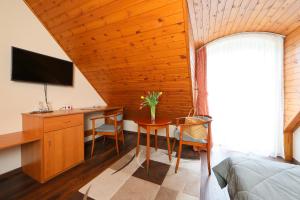 巴拉顿菲赖德布拉茨别墅酒店的一间卧室配有书桌、一张床和一台电视。