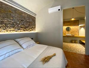 托罗埃利亚-德蒙特格里Casa Elvira的卧室配有白色的床铺和石墙
