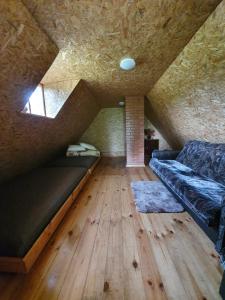 KundzinisķiVēl tuvāk dabai的阁楼间配有沙发和木地板