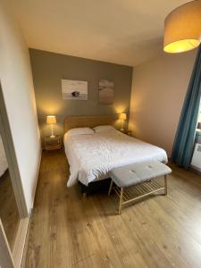 LesperonHôtel et RESTAURANT traditionnel L' Escalandes的一间卧室配有一张大床和两盏灯。