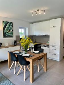 兰肯-格拉尼茨Appartementanlage Lancken-Granitz的厨房配有木桌和黄色鲜花椅子