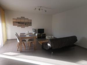奥内莱沙托Appartement T2 accessible PMR avec terrasse et garage的客厅配有桌子和沙发