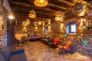 奥赫里德Old Town Hostel Ohrid的客厅设有石墙,配有沙发和椅子