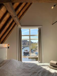 莱顿The Harbour Leiden的一间卧室设有大窗户,享有海港的景色