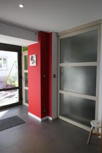阿梅尔斯克维Au Petit Paradis的一间设有滑动玻璃门和红色墙壁的房间
