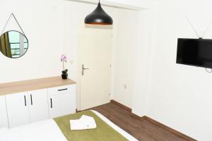 斯特鲁加KLIO Apartments的白色卧室配有床和镜子