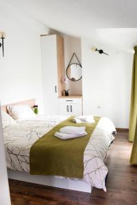斯特鲁加KLIO Apartments的一间卧室配有一张带白色床单和镜子的床