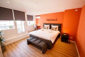 登博斯Trendy Design 55m2 Apartment with Balcony的一间卧室拥有橙色的墙壁、一张床和窗户