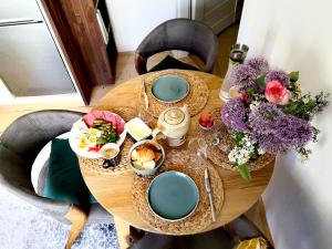 德辛Apartmany Ivana的一张木桌,上面放着食物和鲜花