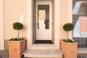 坎诺比奥Antico Borgo B&B的两棵盆栽植物的房子的前门