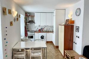 弗拉穆拉Framura, Ampio appartamento con terrazzo vista mare的厨房配有白色的桌椅