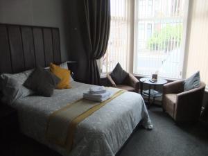 布莱克浦Dewsbury House的卧室配有床、椅子和窗户。