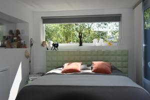 杜斯堡纳因内克住宿加早餐旅馆的一间卧室配有带两个枕头的床和窗户