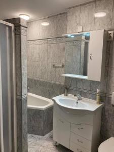久洛Boróka Apartman Gyula的浴室配有盥洗盆和浴缸。