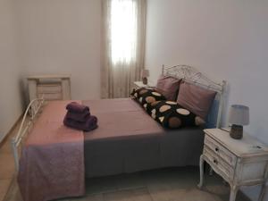 梅伦杜尼奥La Nuova Casetta的一间卧室配有一张床和一张桌子及床头柜