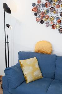 威尼斯Appartamento Piera Rossa info at yourhomefromhomeinvenice-venicerentalapartments dot it的墙上挂着一幅画作的蓝色沙发