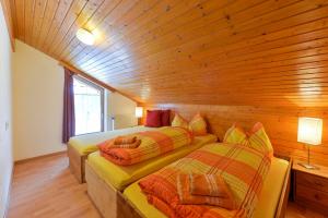 WildenFerienhaus in Klösterle的小木屋内带两张床的房间
