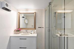 皇后镇Queenstown House Lakeside的白色的浴室设有水槽和淋浴。