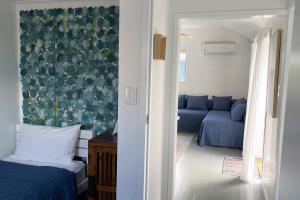 邦加里Breezy Blue on Bribie的一间卧室配有蓝色的床和沙发