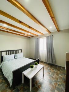 瓜达鲁佩镇Villa Macrina的一间卧室配有一张床和一张桌子,两棵植物