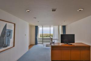 淡路托托海风淡路酒店的客厅配有木柜上的电视