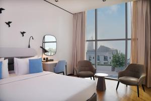 迪拜Lemon Tree Hotel, Jumeirah Dubai的酒店客房设有一张床和一个大窗户