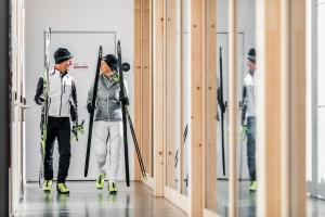 伦策海德Nordic Hostel的男人和女人在滑雪道上走下走廊