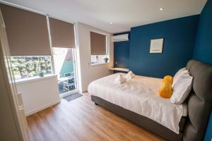 登博斯Boutique Chic 55m2 Apartment with City Garden的一间卧室设有一张床和蓝色的墙壁