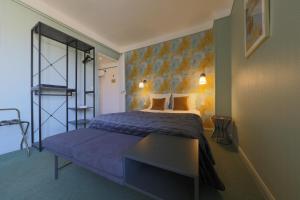 兰斯阿祖尔酒店的一间卧室配有一张大床和蓝色长凳