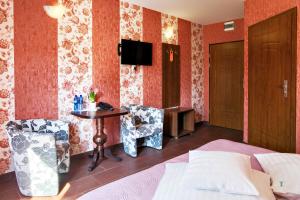斯拉百斯宏达酒店的酒店客房带一张床、一张桌子和椅子