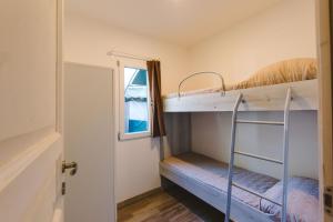 毕博纳的码头Camping Arcobaleno的带两张双层床和一扇门的房间