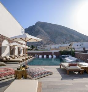 卡马利塞利尼酒店的一个带椅子和遮阳伞的游泳池以及山地