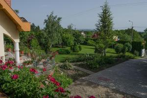 根尼斯迪亚斯博德哈兹旅馆的一座花园,旁边是一座房子,花园内种有粉红色的花朵