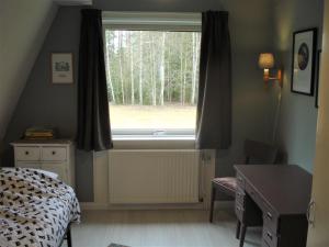 拉达Härlig Heden Vakantiehuis的一间卧室设有一张床和一个树木繁茂的窗户