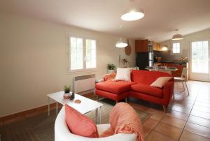 Naujac-sur-MerDomaine du Flamand - Gîtes du Pin Sec côté OCEAN的客厅配有红色的沙发和桌子