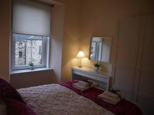 格拉斯哥Fabulous location, One Bedroom West End Flat, just off Byres rd, close to SEC & Hydro的一间卧室配有床、灯和窗户