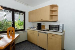 沙普罗德2-Personen-Appartement-in-Schaprode的厨房配有微波炉、桌子和窗户。