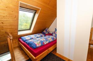 沙普罗德Ferienwohnung-auf-Ruegen-fuer-3-Erwachsene-und-1-Kind的一个小房间的一个床位,设有窗户