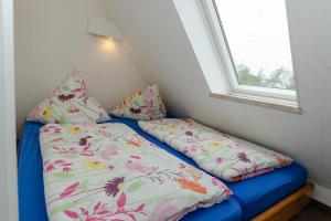 沙普罗德3-Raum-FeWo-auf-Ruegen-fuer-4-Personen的一张带两个枕头的小床和窗户