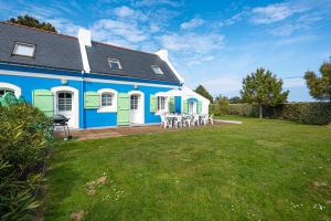 班戈Maison de 3 chambres a Bangor a 500 m de la plage avec jardin clos et wifi的蓝色和白色的房子,有院子