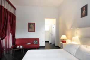 布林迪西Maria Vittoria Charming Rooms and Apartments的一间卧室配有一张床和一张红色的沙发