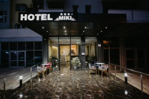 都拉斯Hotel Miki的大楼前设有桌椅的酒店