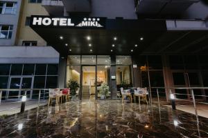 都拉斯Hotel Miki的大楼前设有桌椅的酒店