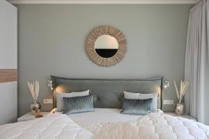 格洛韦Waveside的卧室配有白色床和墙上的镜子