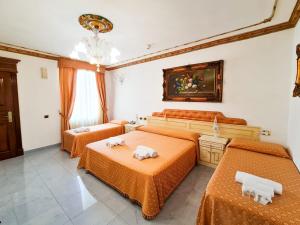 伊格莱西亚斯Euro Hotel Iglesias的配有橙色床单的客房内的三张床
