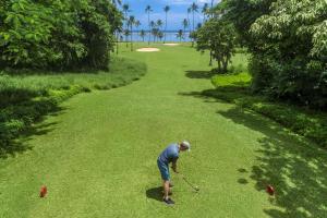 瓦阿Shangri-La Yanuca Island, Fiji的一个人在高尔夫球场打高尔夫