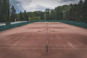 包姚Tenisz Panzió - Baja的一座空的网球场,上面有长凳