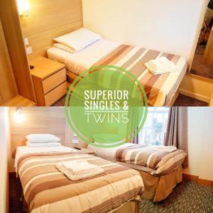 伊普斯威奇卡尔顿酒店的配有高级单人床和两张单人床的酒店客房中的两张床